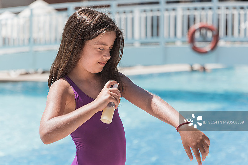 女孩在手上喷洒美黑喷雾图片素材