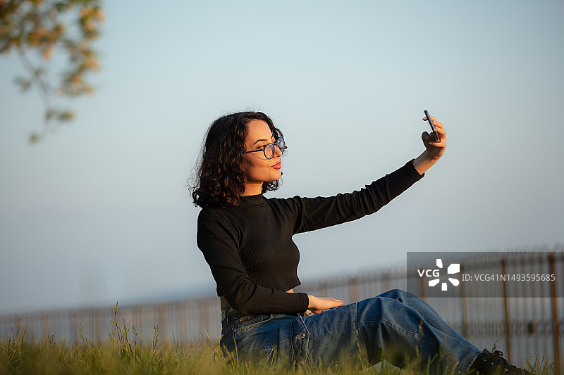 年轻女子在日落时自拍图片素材