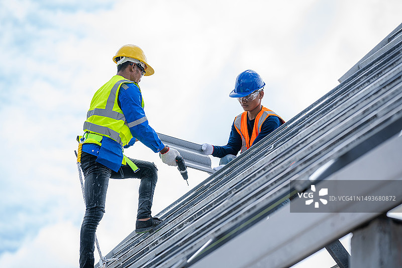 屋顶安装工作中的技术员，工人在屋顶上工作图片素材