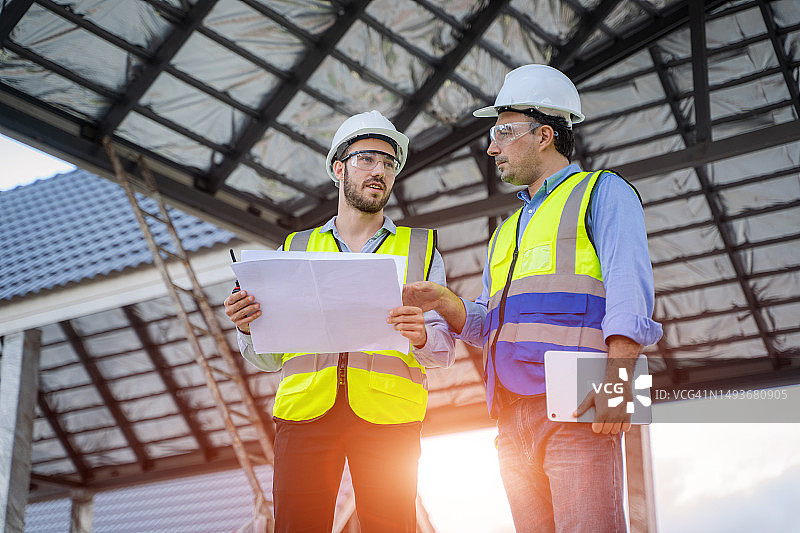 工程师与建筑师查看现代房屋蓝图图片素材