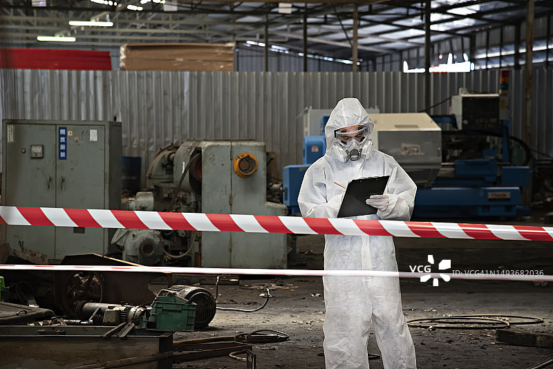 技术员在危险条件下工作，身穿化学防护服和面罩图片素材