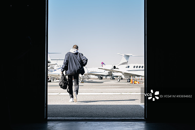 年轻人走出机库图片素材