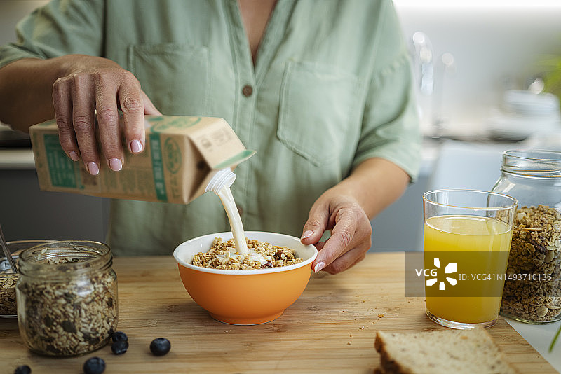 女人准备健康牛奶和麦片早餐图片素材