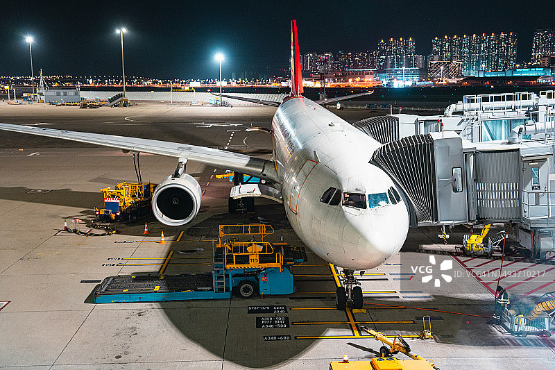 夜间停在机场航站楼的飞机图片素材