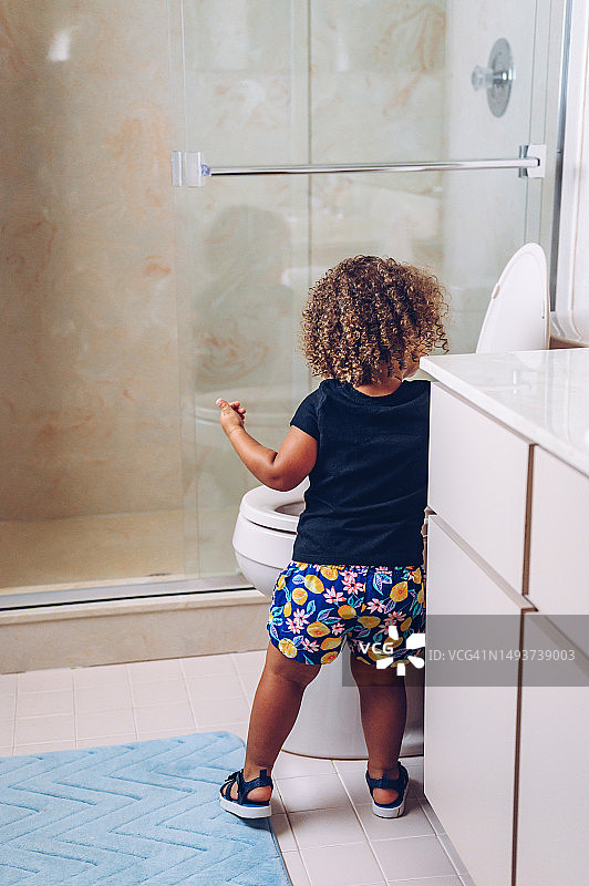 在家中学习使用便盆进行如厕训练的幼儿女孩图片素材
