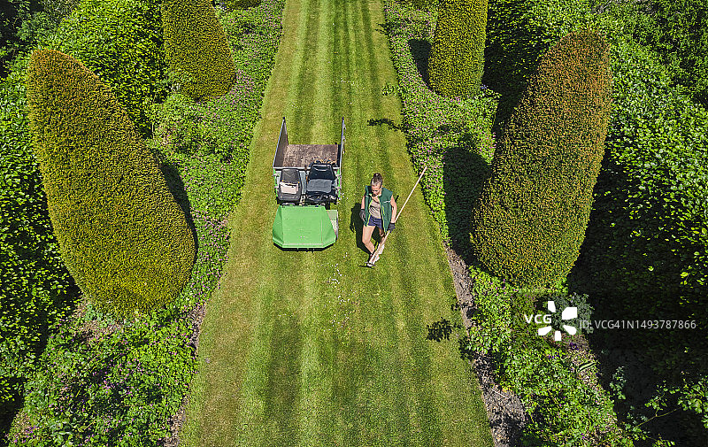 航拍：女子在大草坪花园里工作图片素材