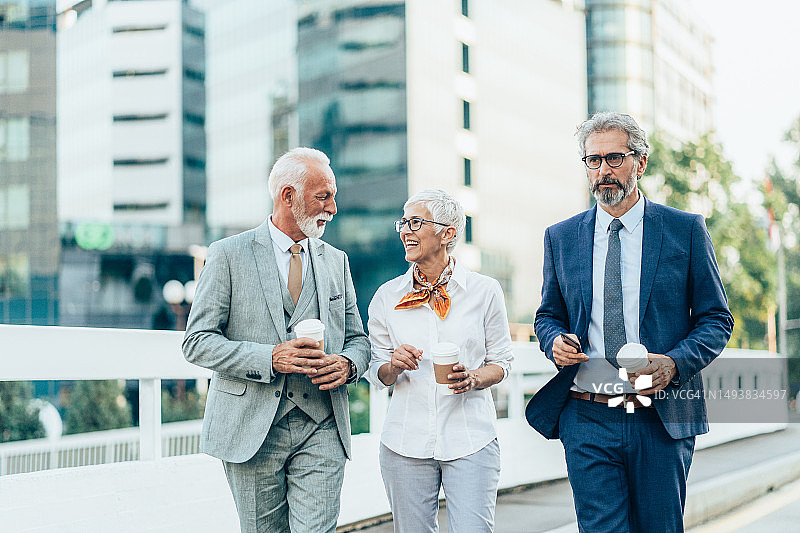 户外行走的三位中年商人图片素材