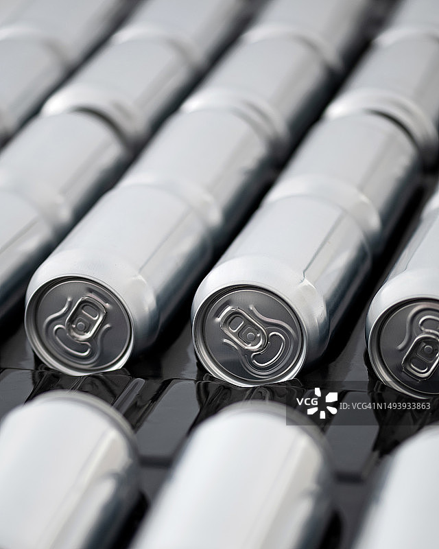 传送带上的饮料罐头，饮料的灌装和包装，饮料生产线，工艺流程，罐头在传送带上，顶视图，柔焦图片素材