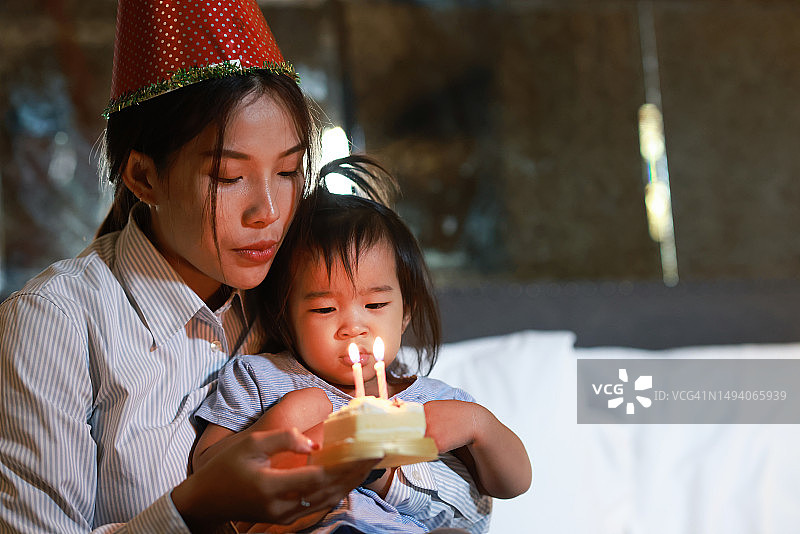 单亲妈妈和女儿在家里的床上一起过生日图片素材