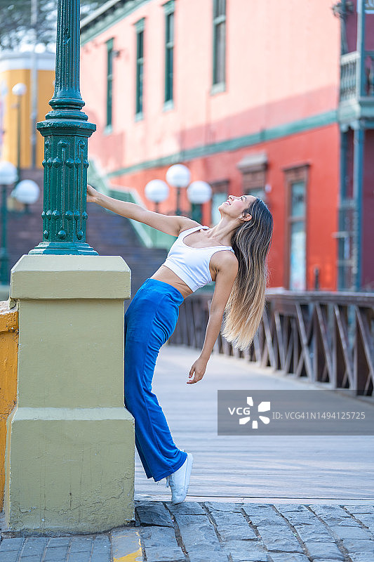 女士在桥上跳舞的竖版照片图片素材