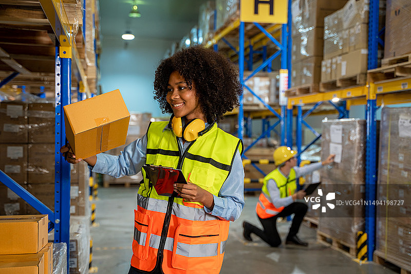 仓库员工清单管理仓库中的包裹箱产品，物流进出口概念图片素材