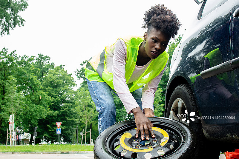 女人正在更换轮胎图片素材