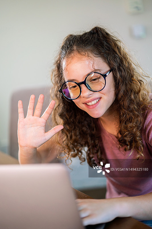 快乐的少女在家中使用笔记本电脑图片素材