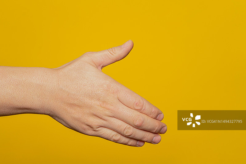 伸出手来握手的男人（黄色背景，已隔离）图片素材