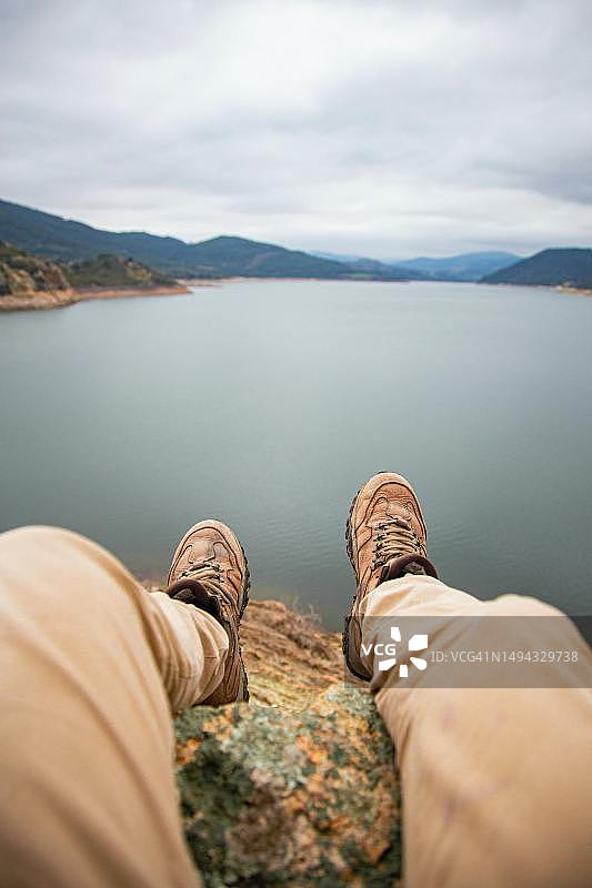 在印度尼西亚北苏门答腊，男人在湖边岩石上放松的下半身照片图片素材