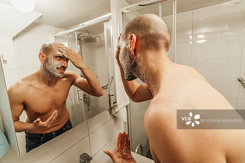 男人在镜子前涂剃须膏图片素材