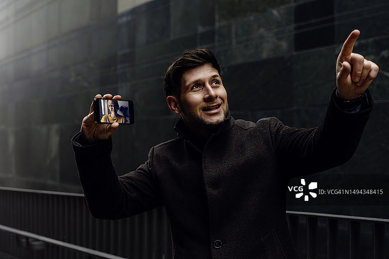 英俊的男人在视频聊天中向女人展示环境中的细节，并对此进行解释。图片素材