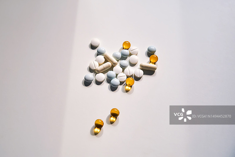 浅色背景上的一把药片、维生素和微量元素图片素材