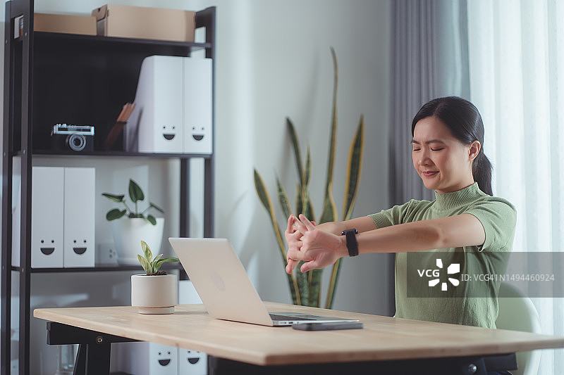 亚洲女人在家办公时手痛图片素材