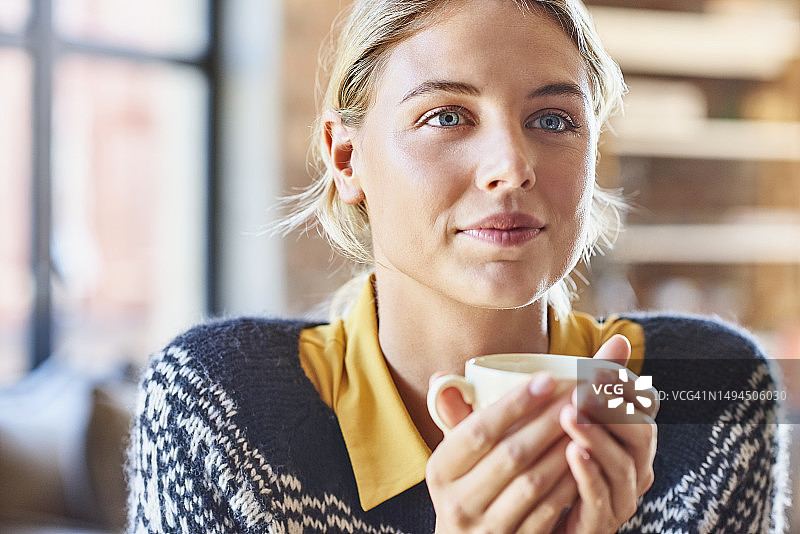 在家 holding 咖啡杯的沉思年轻女人图片素材