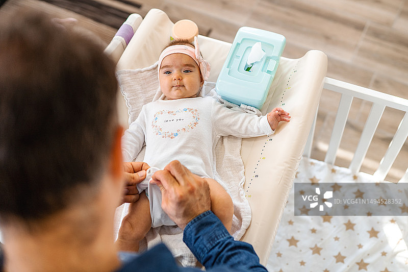 父亲给小女儿换尿布图片素材