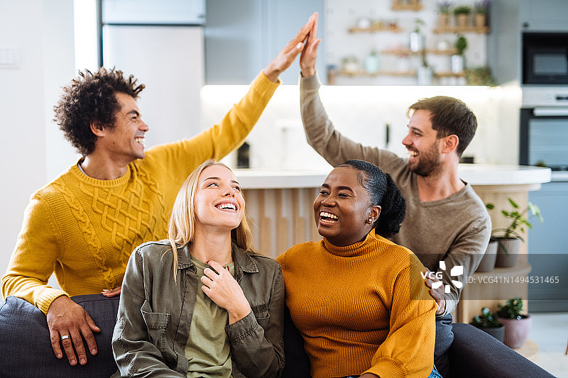 两对不同肤色的情侣在家玩电子游戏，气氛欢乐图片素材