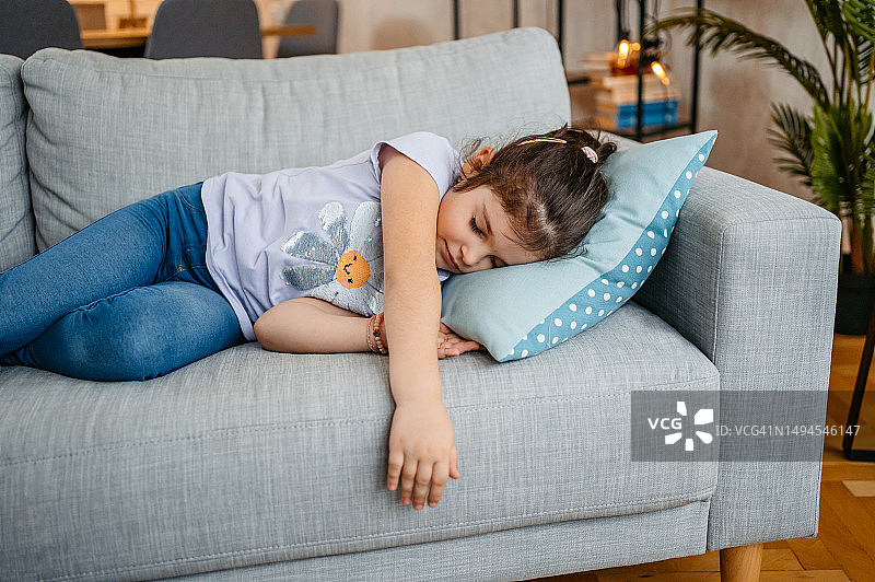 在客厅沙发上睡觉的小女孩图片素材