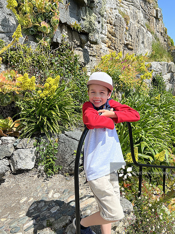 在亚热带花园里摆姿势的男孩图片素材