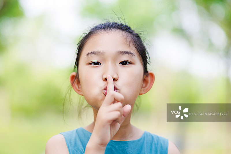 小女孩手指放在嘴唇上图片素材