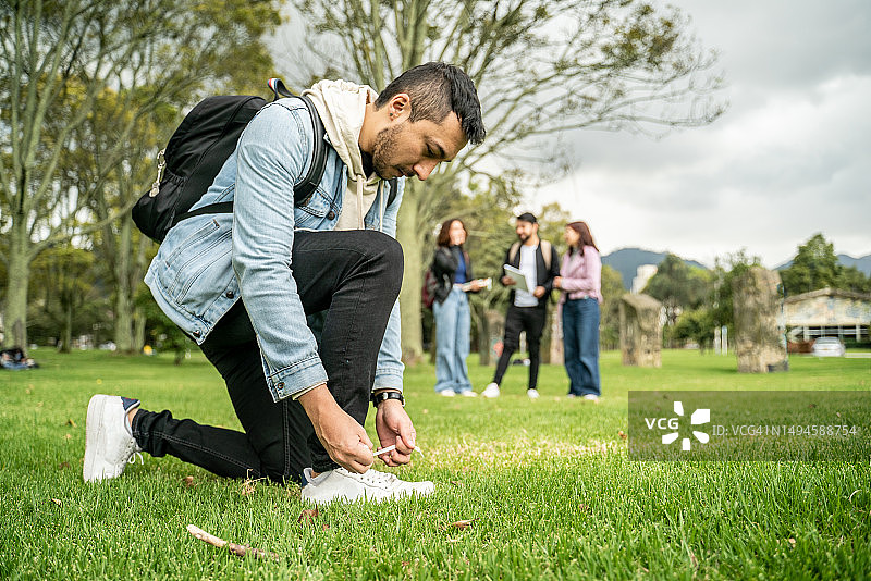 年轻学生在大学校园里系网球鞋带图片素材