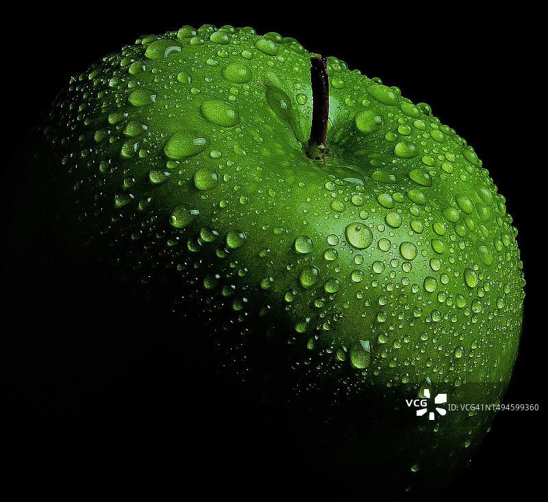黑色背景下的湿苹果特写图片素材