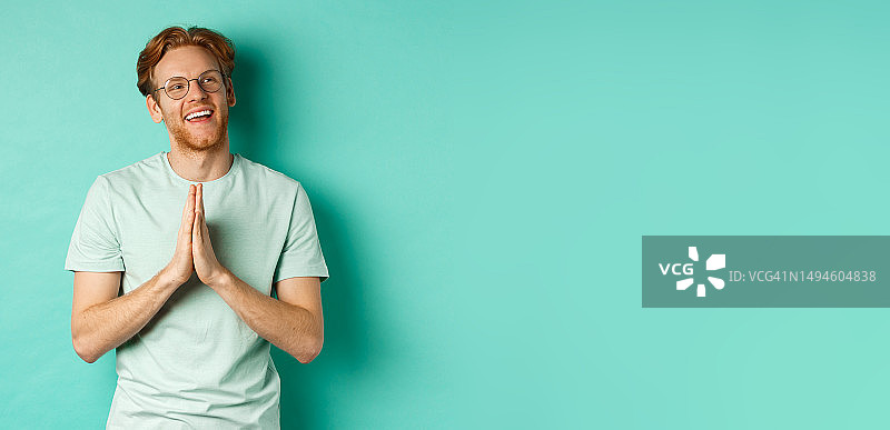 充满希望的留着胡子的红发男人，戴着眼镜和T恤图片素材