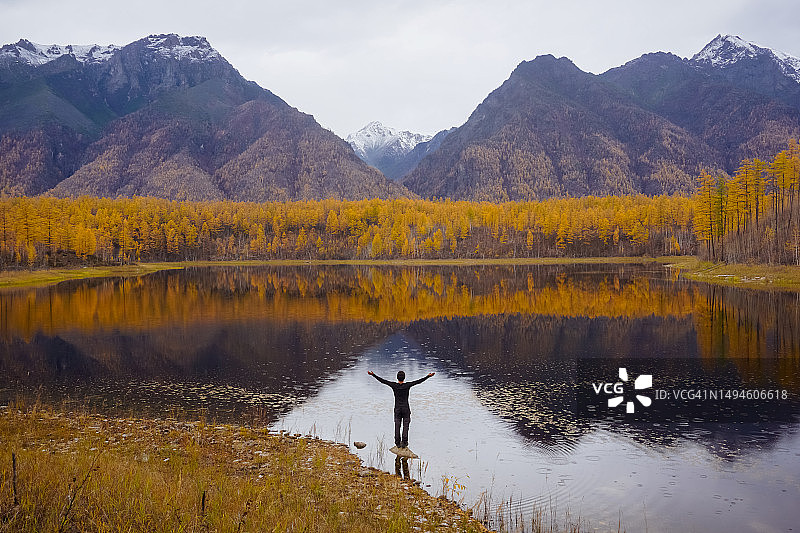 男子站在湖边，背景是俄罗斯的恰拉山图片素材
