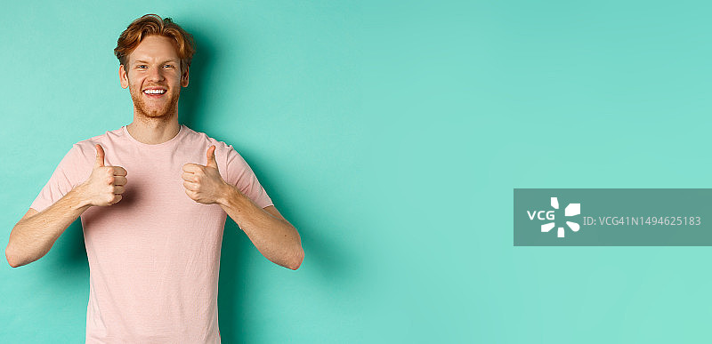 快乐的红发络腮胡男子竖起大拇指，表示喜欢和赞同图片素材