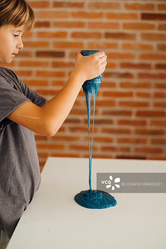 小男孩在家玩黏液泥图片素材