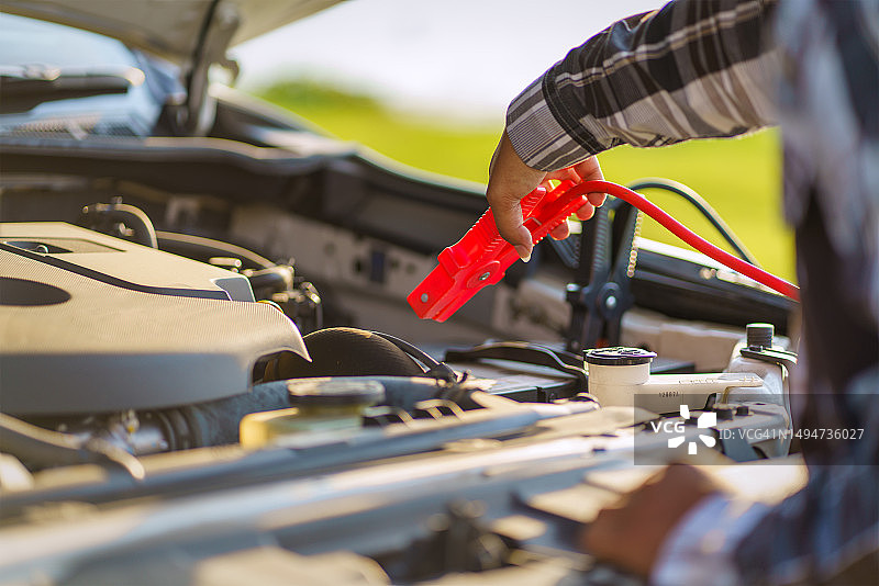 男子在晴天检查抛锚的汽车，汽车故障图片素材