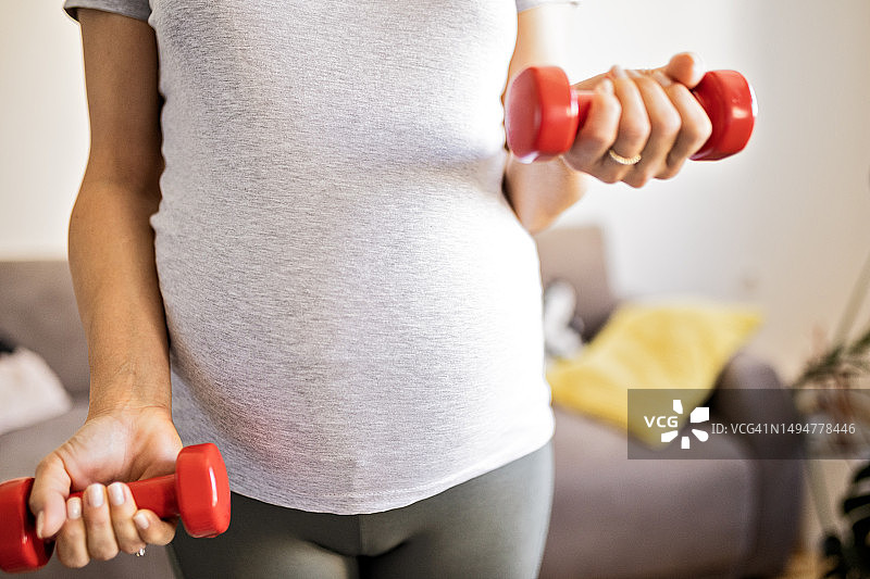 孕妇在家用哑铃做运动图片素材