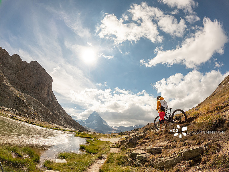 女人在瑞士的土路上推着自行车图片素材