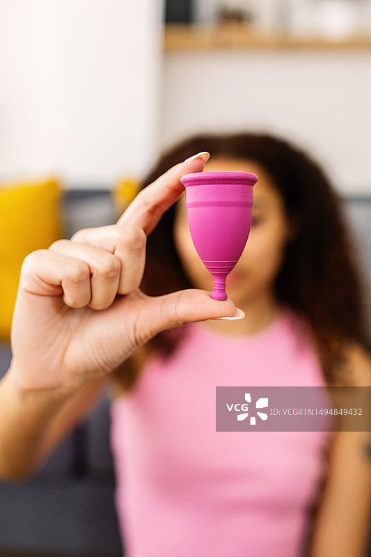手持环保硅胶月经杯的微笑少女图片素材