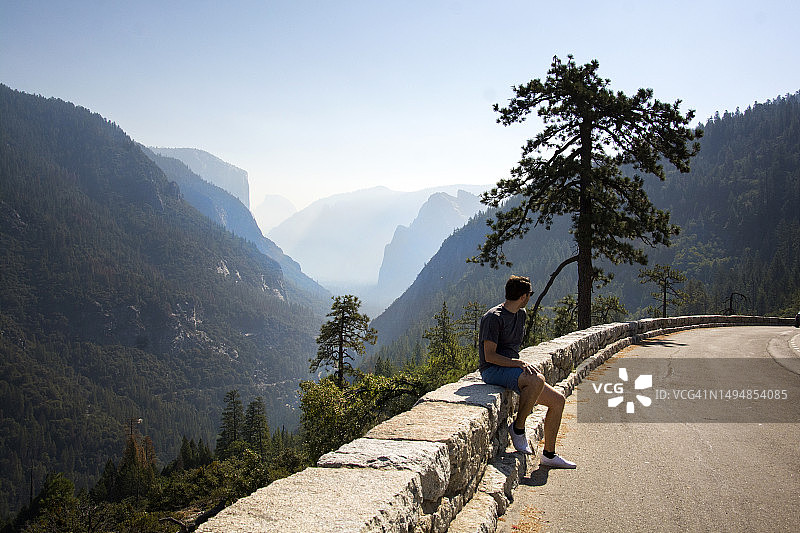 男子在美国加利福尼亚州优胜美地国家公园的隧道中欣赏全景图片素材