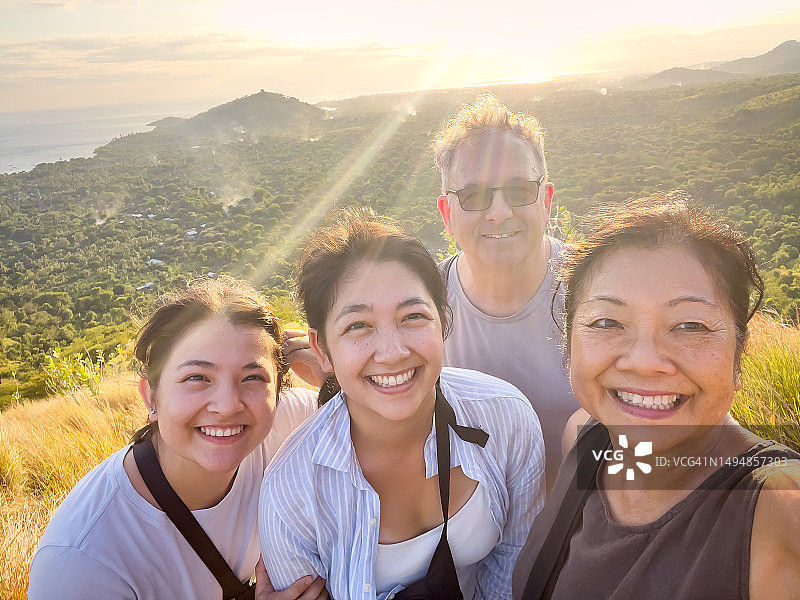 多民族徒步者，成年女儿，年长父母在山顶欣赏风景图片素材