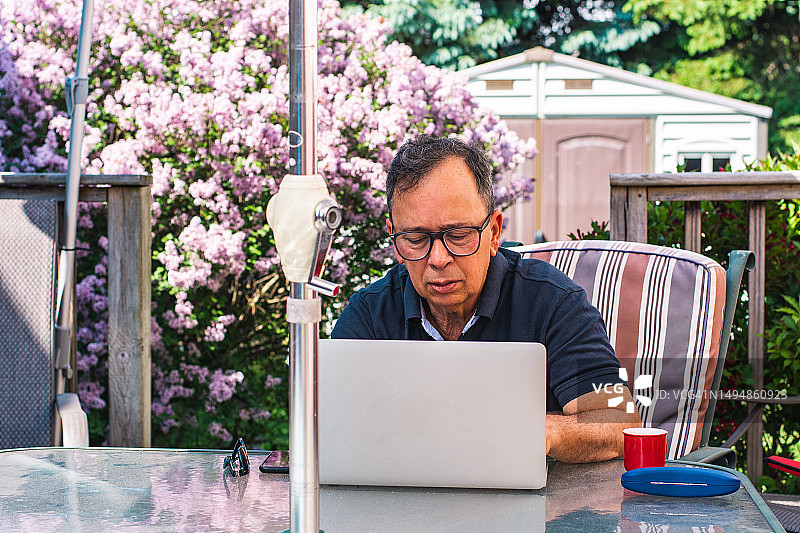 男人在阳台上使用笔记本电脑图片素材