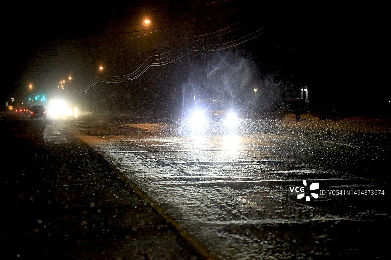 黑暗乡村公路上明亮的车头灯图片素材