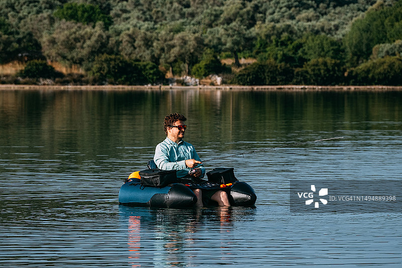 男子在充气船上钓鱼图片素材