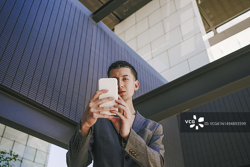 在办公楼用手机自拍的休闲商务男士图片素材