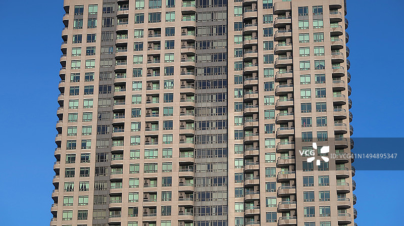 高层住宅楼的窗户和阳台，背景为蓝天图片素材