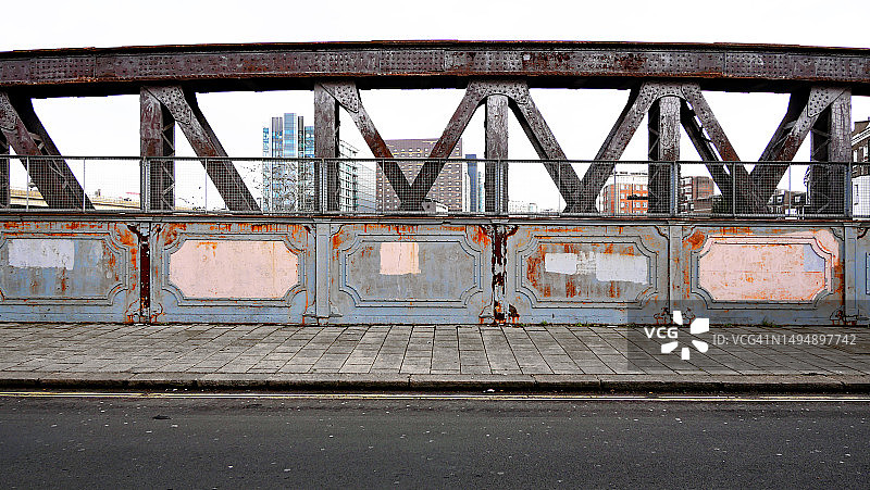 英国伦敦带人行道和街道的铁路桥的彩绘、风化和锈蚀金属结构图片素材