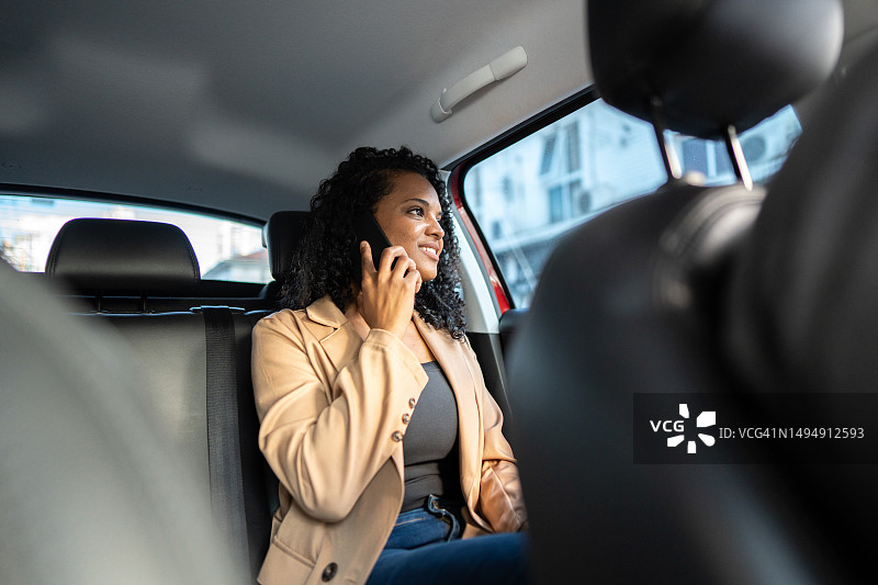 在出租车上打电话的中年妇女图片素材