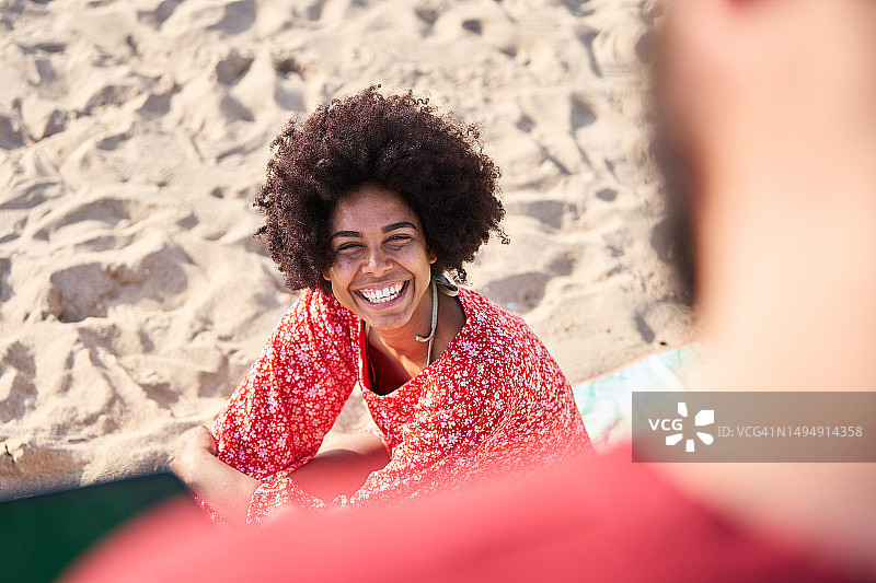 快乐的非洲女人在海滩上对着男人微笑图片素材