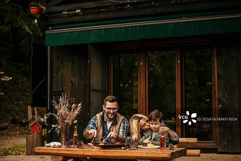 温馨家庭：孩子在阳台上用餐图片素材